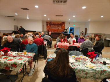Wide view of people at tables sitting and talking.