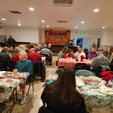 Wide view of people at tables sitting and talking.